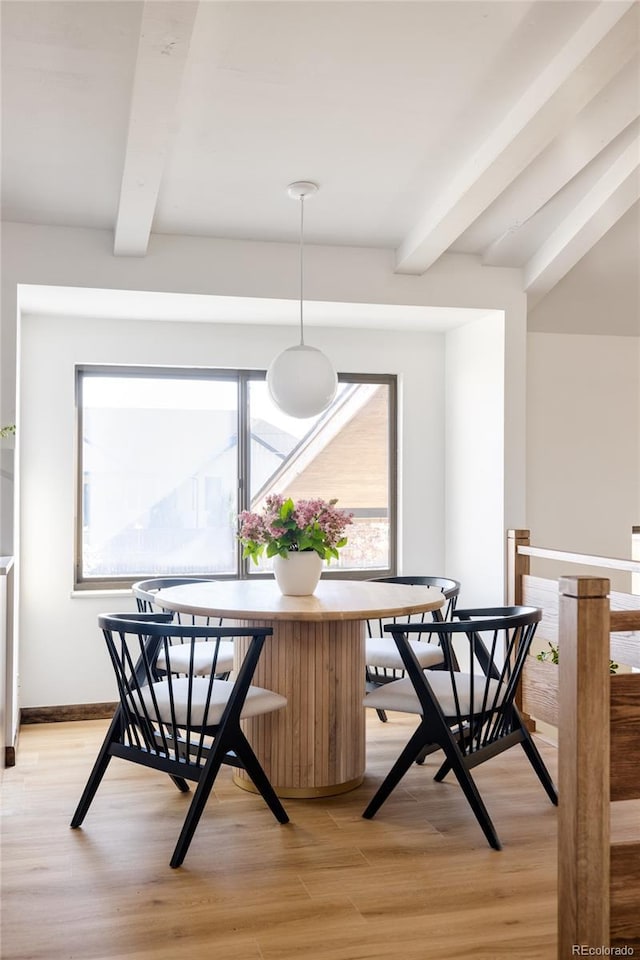 dining space featuring beamed ceiling and light hardwood / wood-style flooring