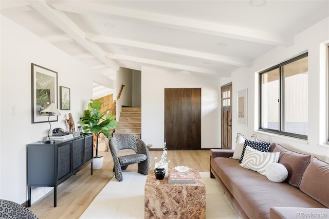 living room with light wood-type flooring and vaulted ceiling with beams