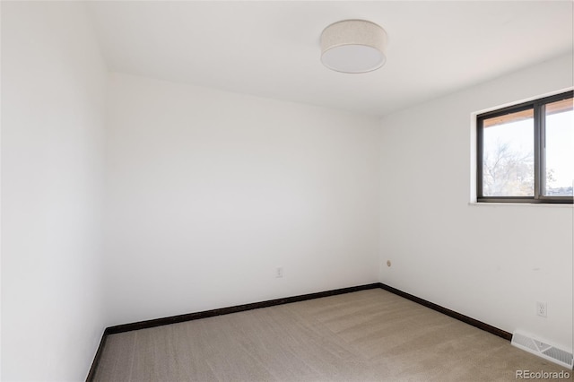 unfurnished room featuring light colored carpet