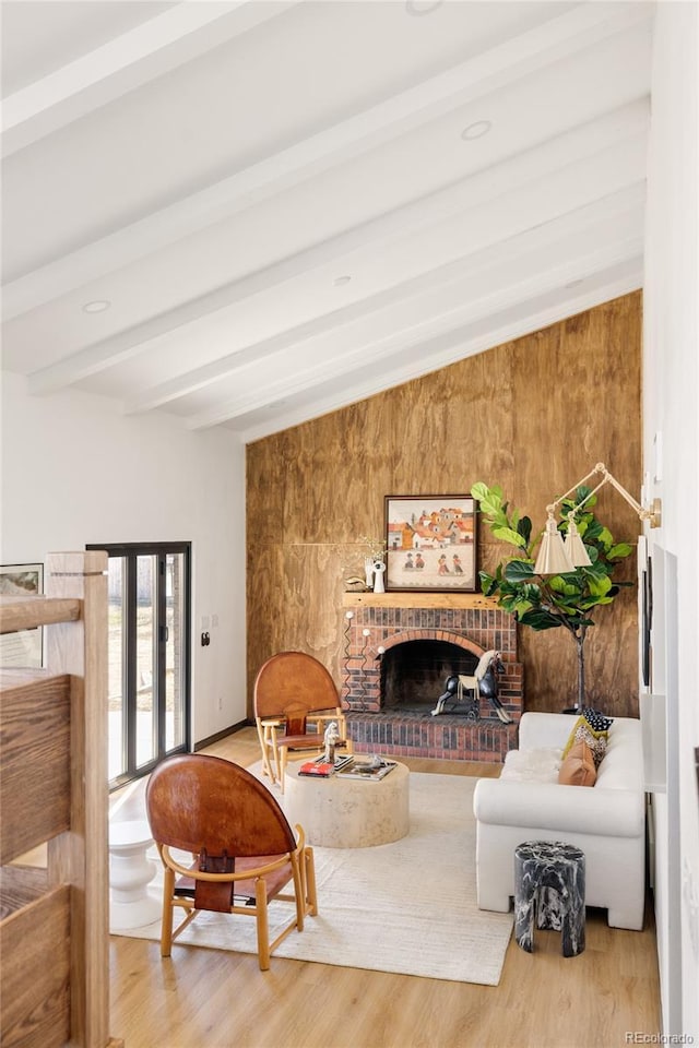 living room featuring beam ceiling, a fireplace, and hardwood / wood-style floors