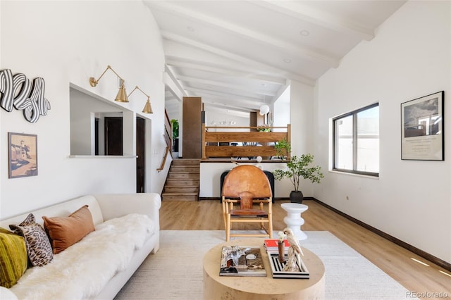 living room featuring lofted ceiling with beams and light wood-type flooring