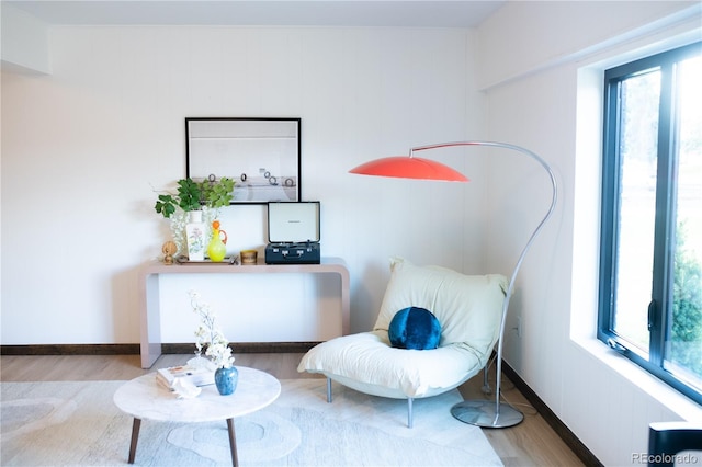 living area with hardwood / wood-style floors and a healthy amount of sunlight