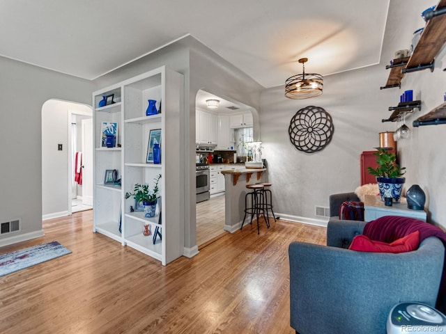 4540 Yarrow St, Wheat Ridge, CO 80033 - living room featuring arched walkways and light wood-type flooring