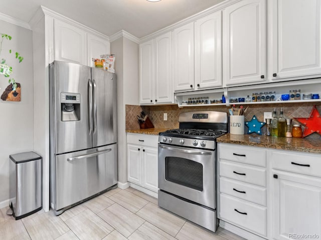 4540 Yarrow St, Wheat Ridge, CO 80033 - kitchen featuring stainless steel appliances, white cabinetry, backsplash, dark stone countertops, and crown molding
