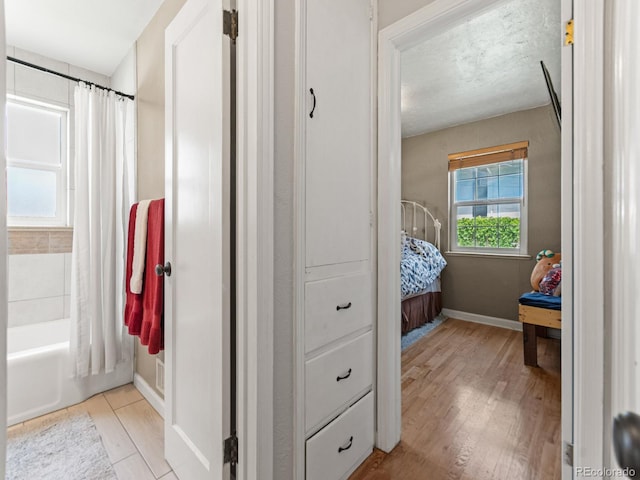 4540 Yarrow St, Wheat Ridge, CO 80033 - ensuite bathroom with wood finished floors and shower / bathtub combination with curtain