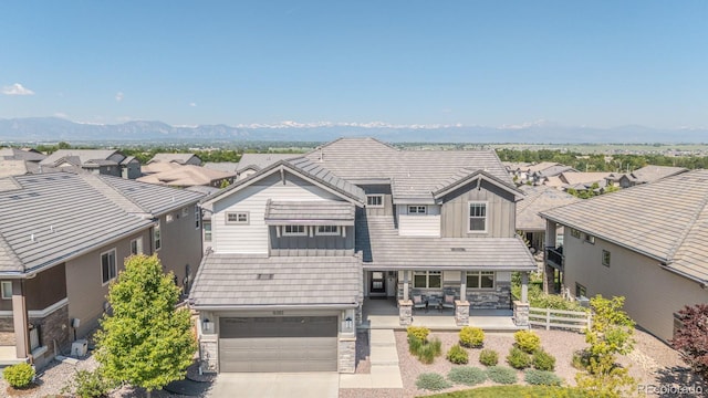 16383 Ute Peak Way, Broomfield, CO 80023 - view of front of property with stone siding, board and batten siding, a residential view, a mountain view, and a garage