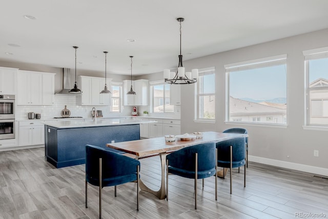 16383 Ute Peak Way, Broomfield, CO 80023 - dining room featuring light wood finished floors, a chandelier, healthy amount of natural light, and recessed lighting