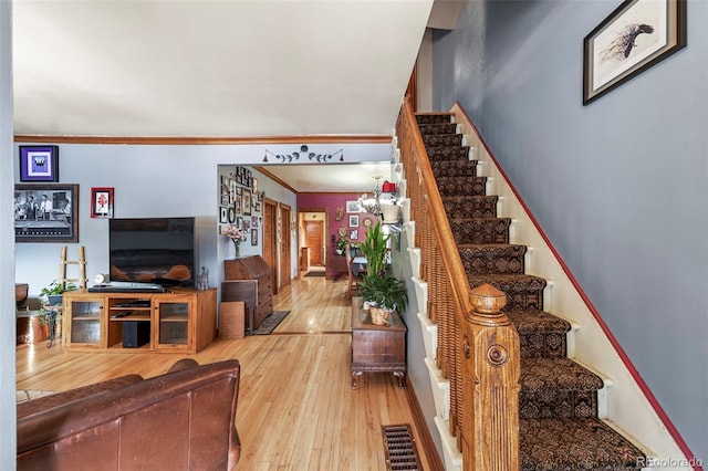 staircase featuring crown molding and wood-type flooring