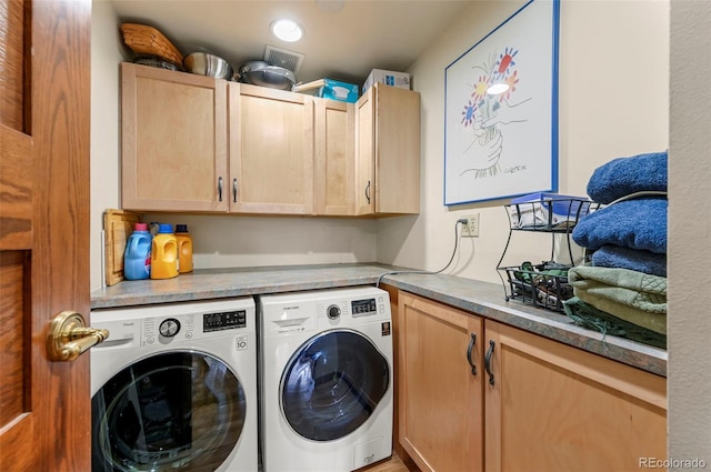 washroom with cabinets and washer and dryer