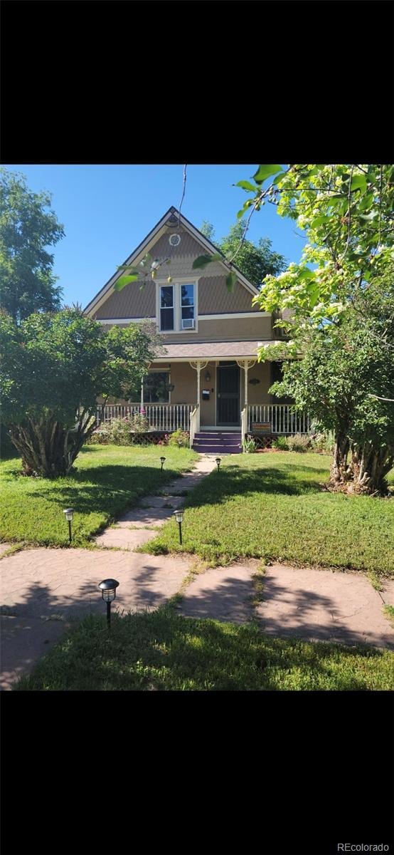 view of front of property with a porch and a front lawn