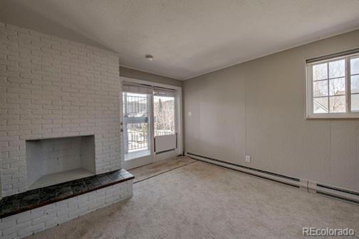 214 N Main St Unit 14, Breckenridge, CO 80424 - unfurnished living room with carpet floors, a brick fireplace, and a textured ceiling