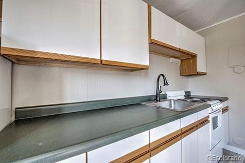 214 N Main St Unit 14, Breckenridge, CO 80424 - kitchen featuring white cabinets, white gas range oven, and a sink