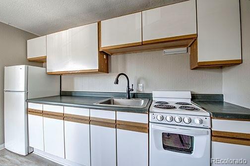 214 N Main St Unit 14, Breckenridge, CO 80424 - kitchen featuring white appliances, a sink, white cabinets, a textured ceiling, and dark countertops