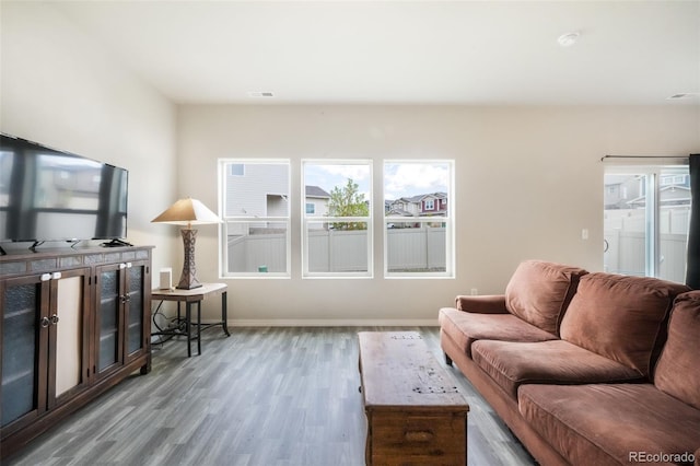 living room with visible vents, baseboards, and wood finished floors