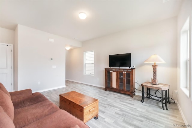 living area featuring baseboards and wood finished floors