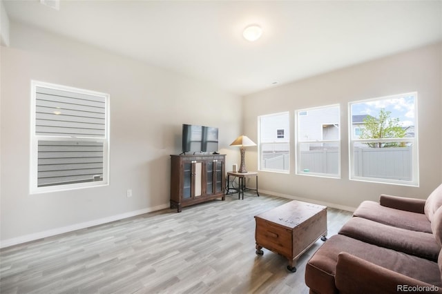 living area featuring baseboards and wood finished floors