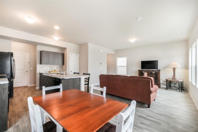 dining area featuring baseboards and light wood-style flooring