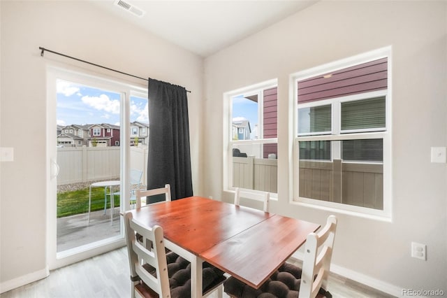 dining room with visible vents, light wood-style flooring, and baseboards