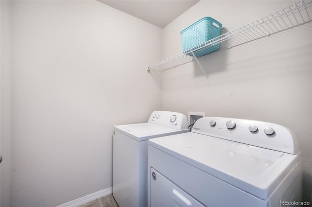 laundry area with independent washer and dryer, laundry area, baseboards, and light wood-style floors