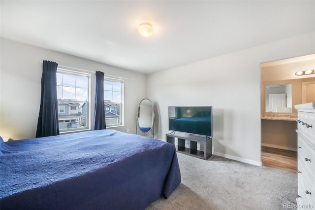 bedroom with baseboards, carpet flooring, and connected bathroom
