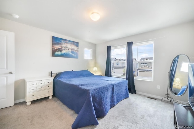 bedroom featuring baseboards, light colored carpet, and visible vents