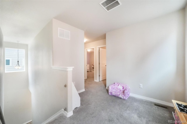 carpeted spare room featuring baseboards and visible vents