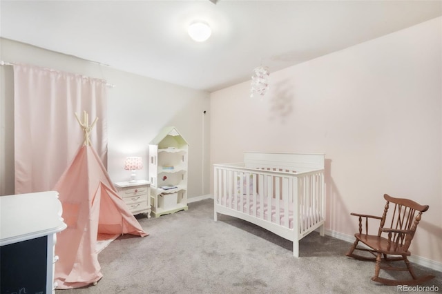 bedroom featuring baseboards, carpet flooring, and a crib