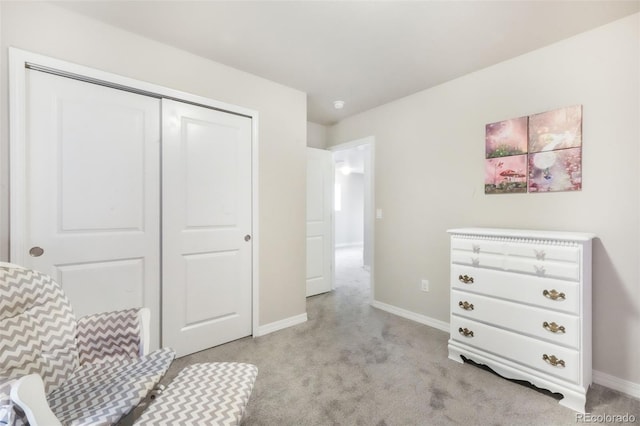 bedroom with baseboards, light carpet, and a closet