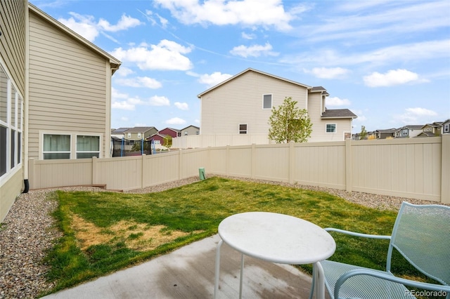 view of yard featuring a residential view, a fenced backyard, and a patio area
