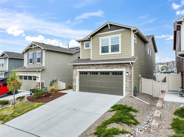 craftsman-style house with an attached garage, fence, driveway, and stone siding