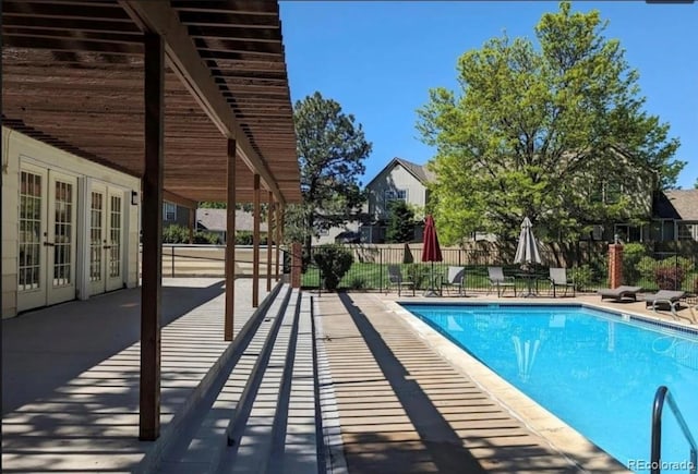 view of swimming pool featuring a patio area and french doors