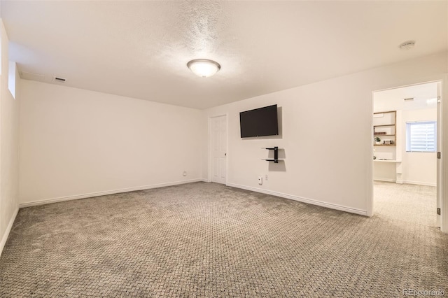 empty room featuring carpet floors and a textured ceiling