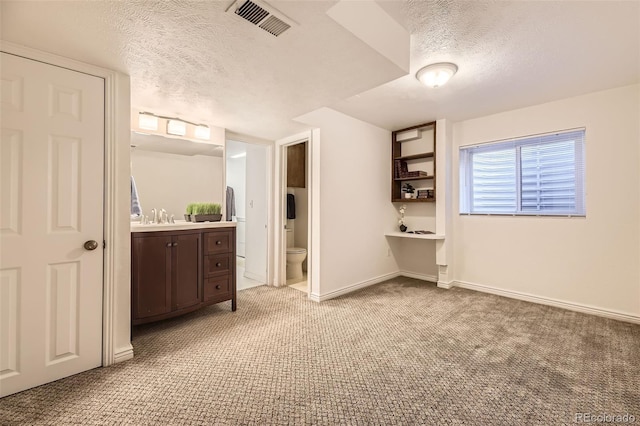 bathroom with vanity, toilet, and a textured ceiling