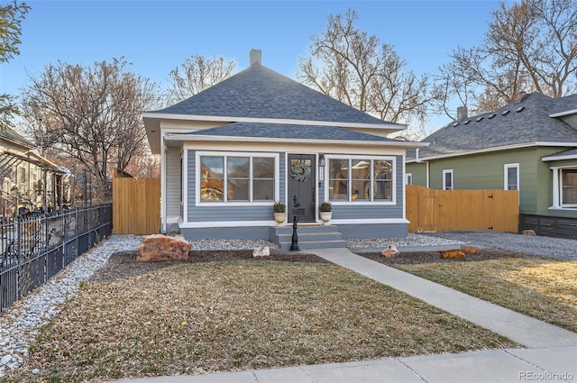 bungalow with a gate, roof with shingles, and fence