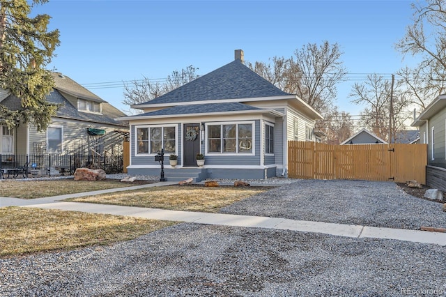 bungalow-style house featuring a gate, driveway, a shingled roof, and fence