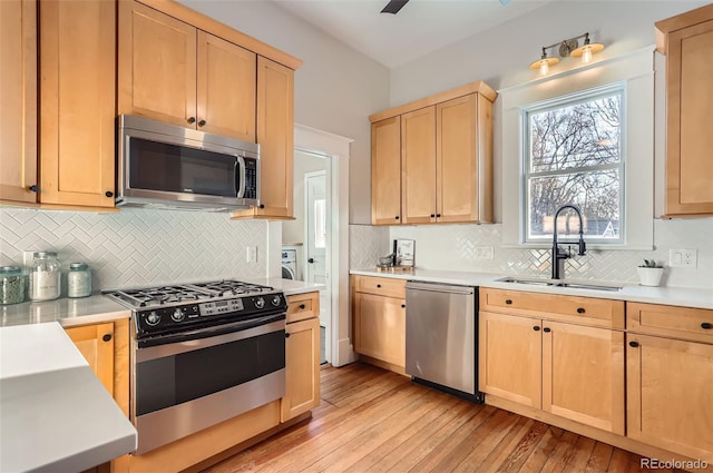 kitchen with light countertops, light brown cabinets, appliances with stainless steel finishes, and a sink