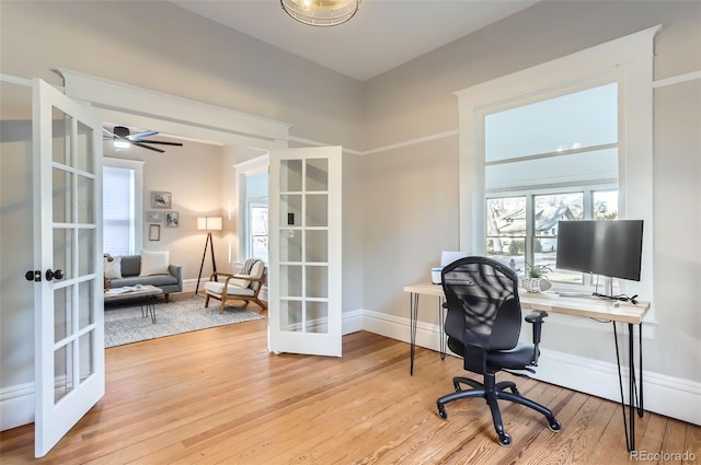 office area with french doors, baseboards, light wood-style flooring, and a ceiling fan