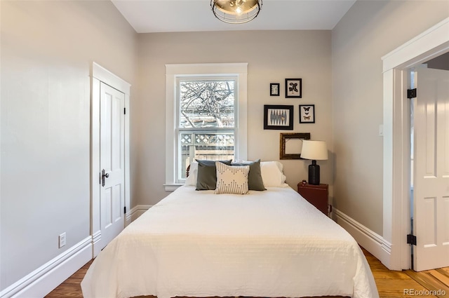 bedroom featuring baseboards and wood finished floors