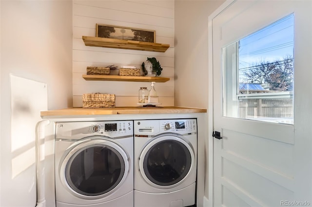 laundry area featuring washer and dryer, laundry area, and wooden walls