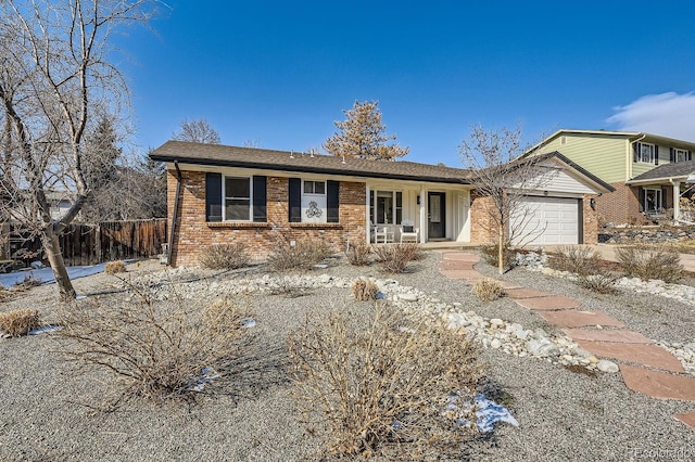 ranch-style home featuring a garage, brick siding, and fence