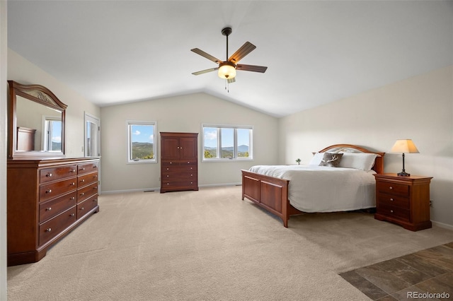bedroom featuring lofted ceiling, ceiling fan, baseboards, and light colored carpet