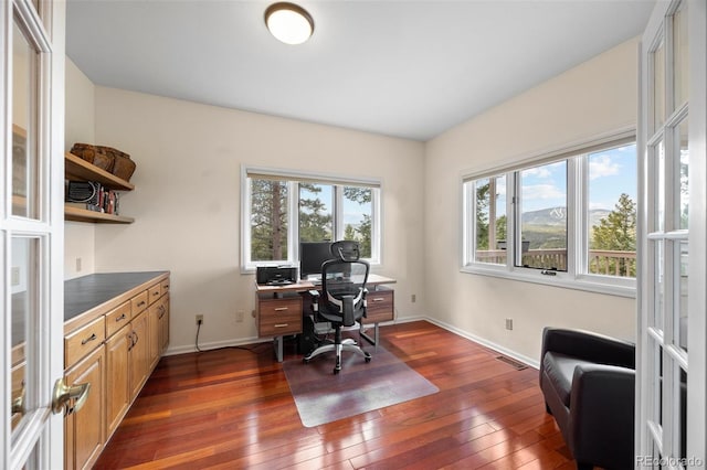 office space with dark wood-style flooring, baseboards, and healthy amount of natural light