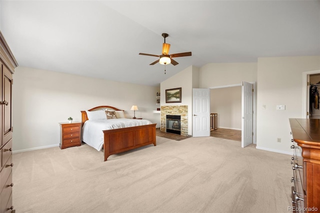 8724 Armadillo Trl, Evergreen, CO 80439 - bedroom with light carpet, vaulted ceiling, a stone fireplace, and a ceiling fan