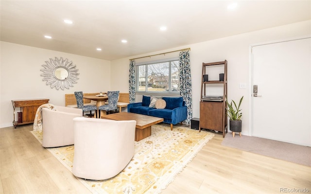 living area with light wood-style flooring and recessed lighting