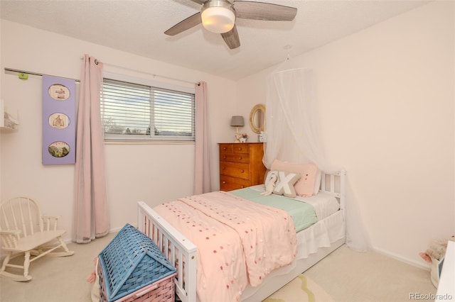 carpeted bedroom featuring a textured ceiling, a ceiling fan, and baseboards