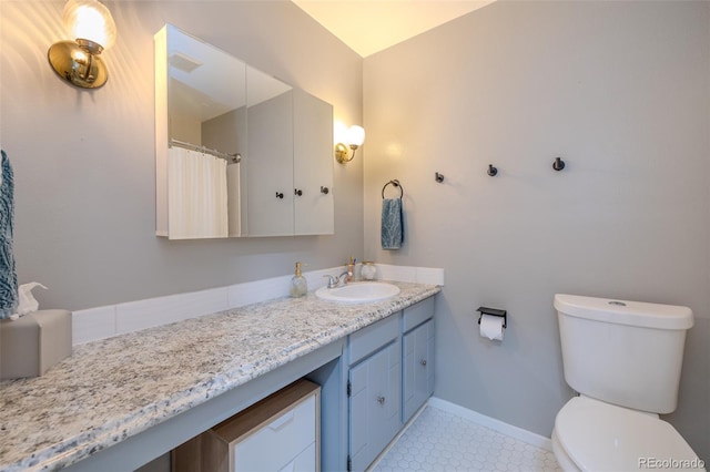 bathroom with toilet, tile patterned floors, baseboards, and vanity