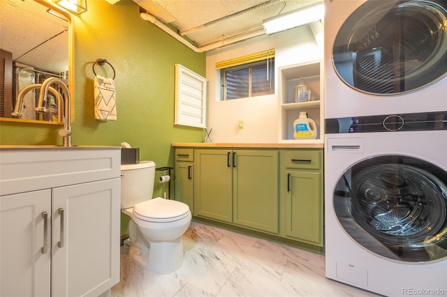 laundry room with laundry area, marble finish floor, and stacked washing maching and dryer