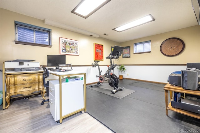 exercise room with visible vents and baseboards