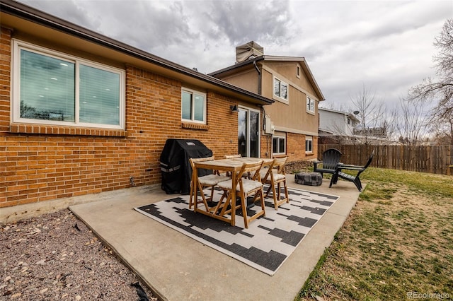 view of patio with an outdoor fire pit, fence, and grilling area