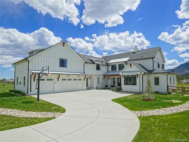 modern inspired farmhouse with fence, board and batten siding, an attached garage, and a standing seam roof